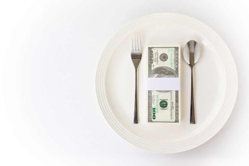 Dollar bills on plate representing the concept of how to start a restaurant with no money