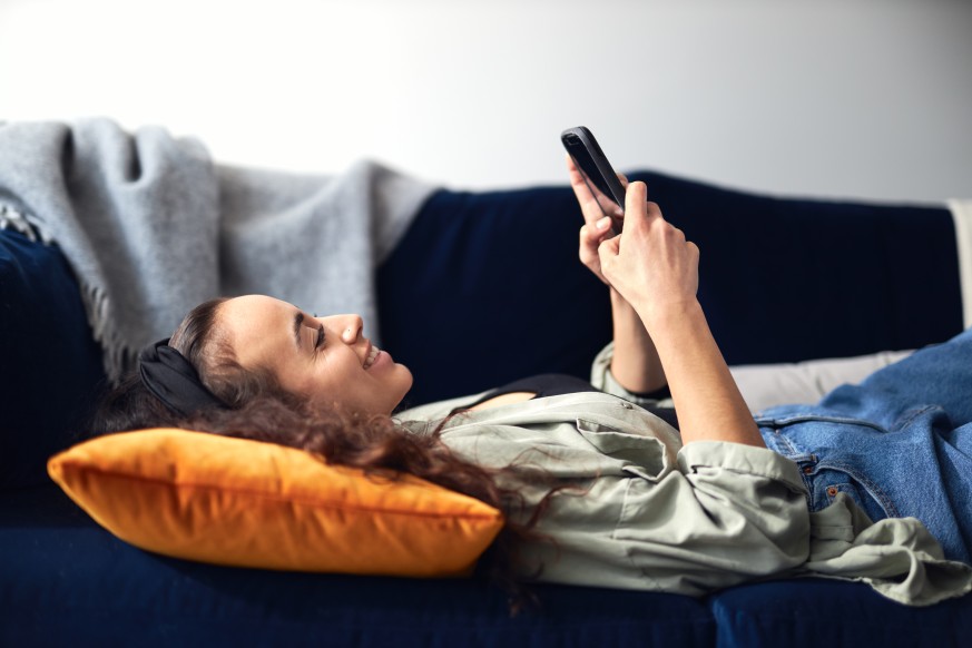 Young Smiling Woman Female Laid Down Sofa Cushion Smartphone Social Media Engagement