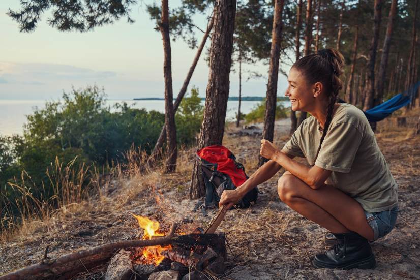 Happy Woman Traveler Backpacker Camping Taking Care of Fire