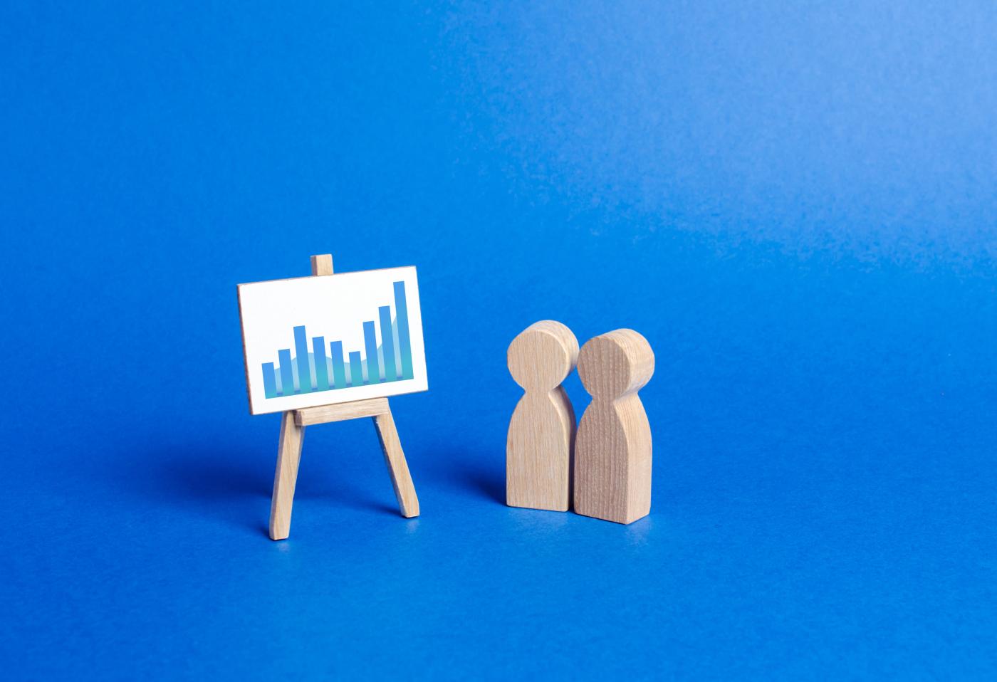 Figures of people look at the stand with positive trend chart and discussing advertising analytics