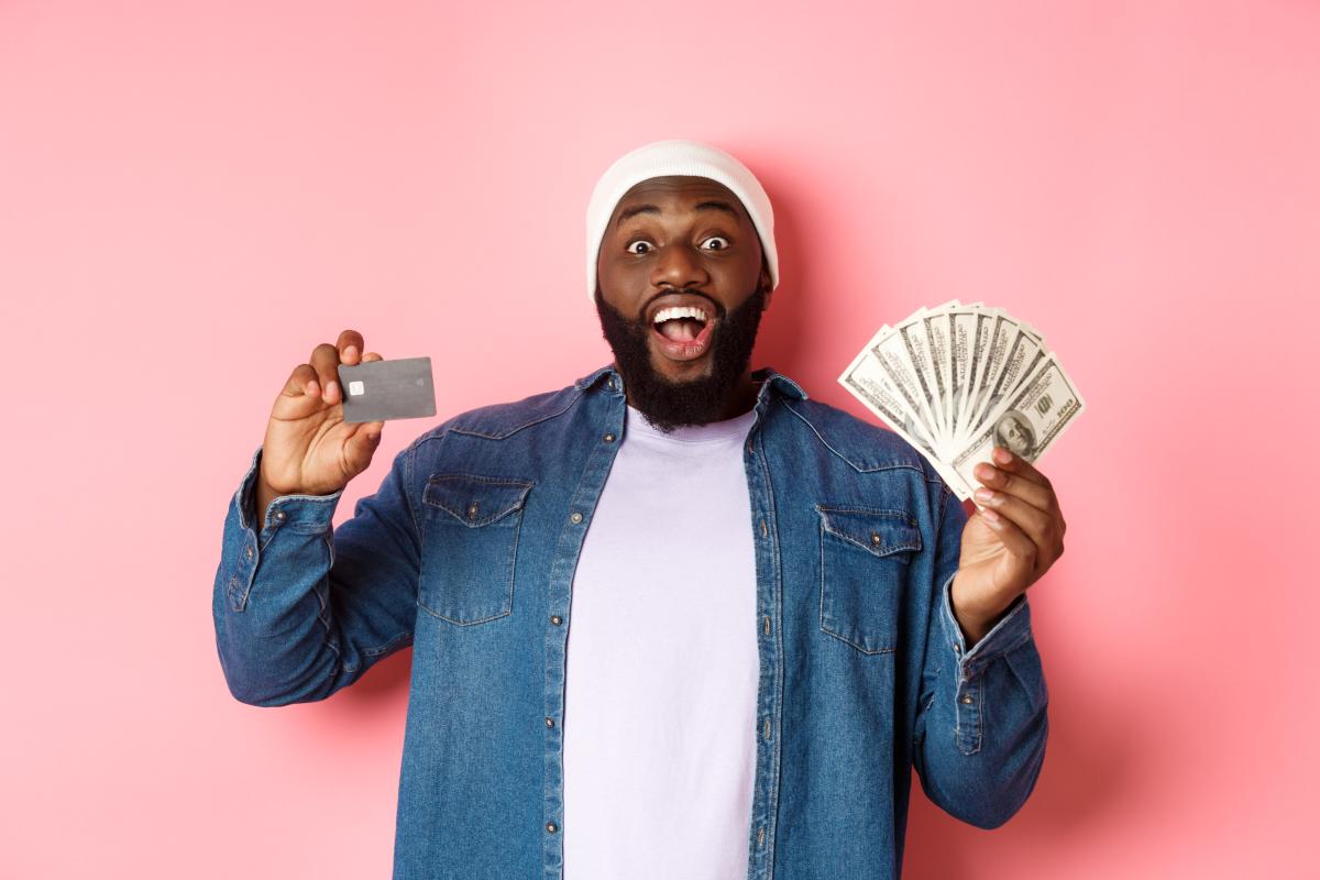 An excited eCommerce specialist showing credit card and dollars on hand