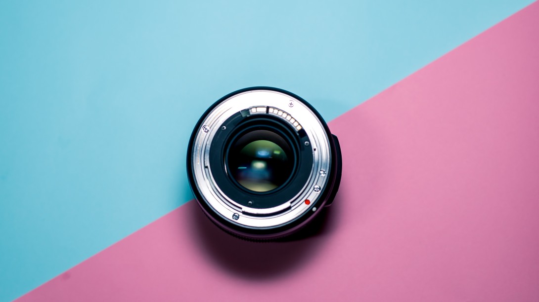 Camera lens over a blue and pink background