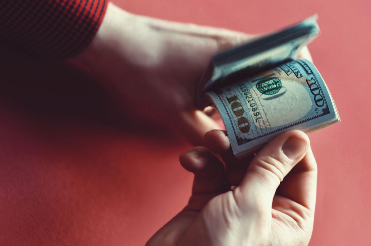 Hand holding banknotes ready to buy LinkedIn connections