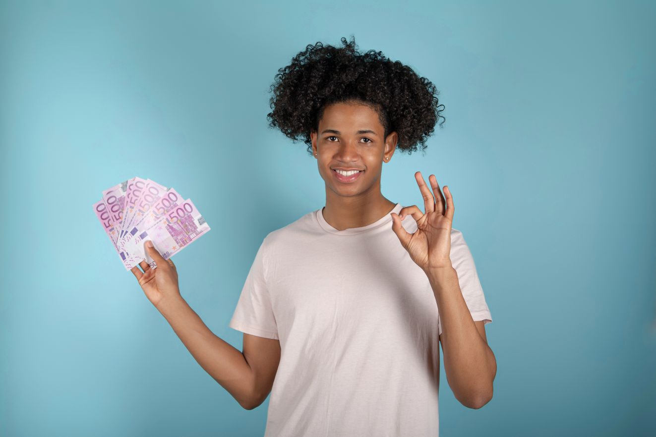 Man holding euro banknotes making ok sign with fingers on a blue background