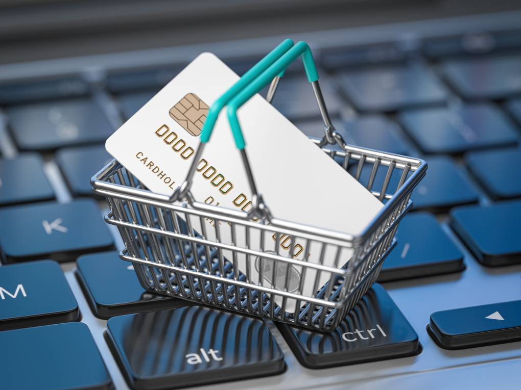 Shopping basket with credit card on laptop keyboard
