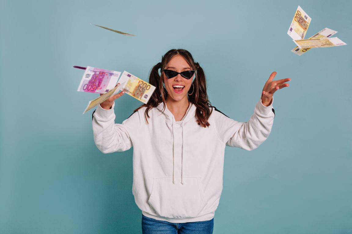 Woman standing in a room with flying bills