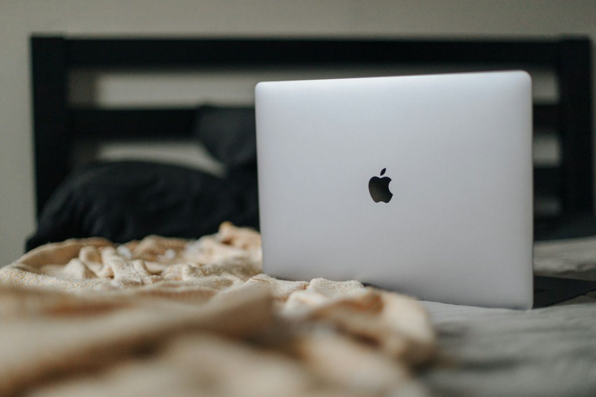 Apple laptop on bed. The company is one of the use cases showing the Practical Applications of The Growth Matrix