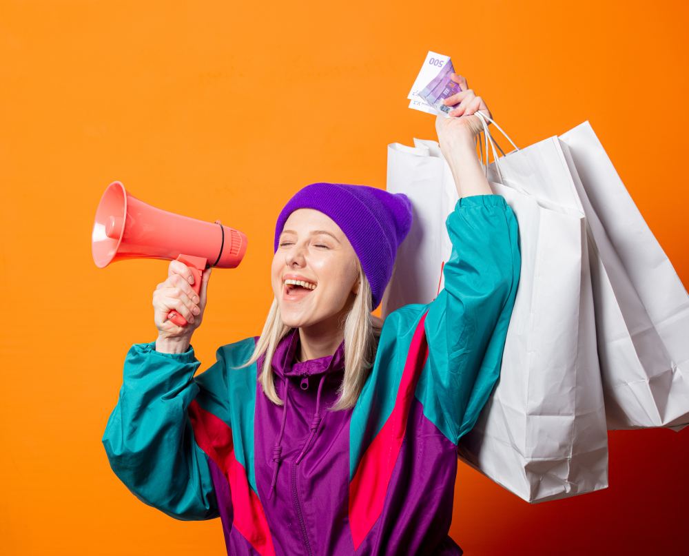 Woman in 90s tracksuit with megaphone and shopping bags