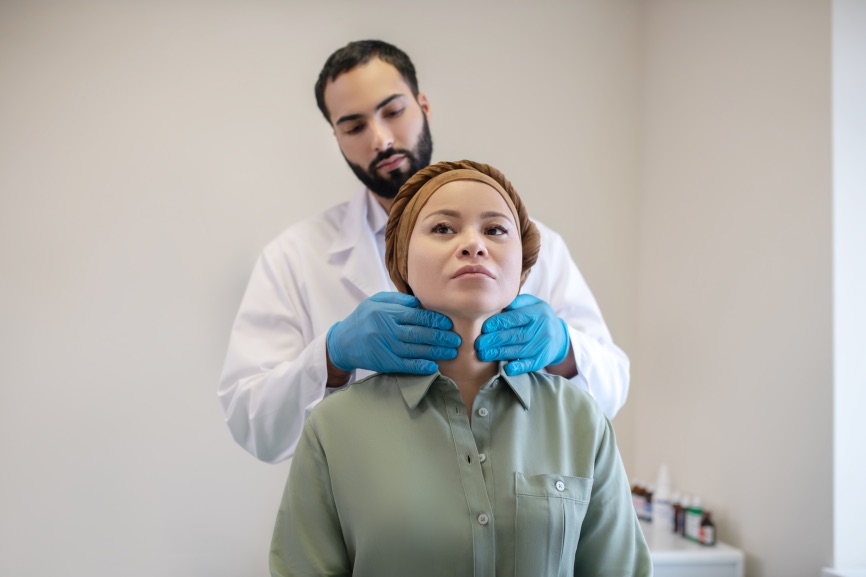 Male Plastic Surgeon Examining Neck Female Patient