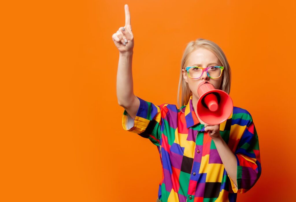 Style blonde in 90s clothes and rainbow glasses with megaphone calling customers to act so she can grow Google Business Profile audience for her small business.